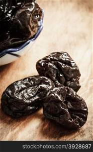 Healthy food, good cuisine. Closeup dried plums prunes fruits on wooden rustic table background