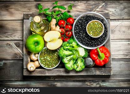 Healthy food. Healthy assortment of vegetables and fruits with legumes. On a wooden background.. Healthy food. Healthy assortment of vegetables and fruits with legumes.