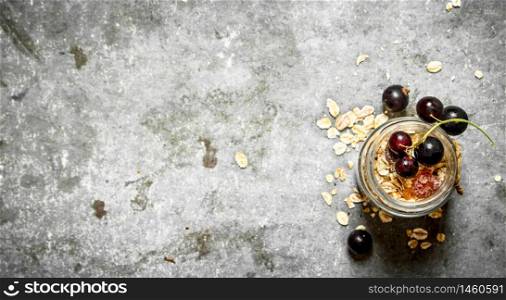 Healthy food. Muesli with black currant. On the stone table.. Healthy food. Muesli with black currant.