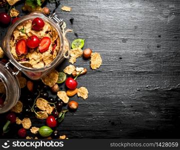 Healthy food. Muesli with forest berries. On a black wooden background.. Healthy food. Muesli with forest berries.