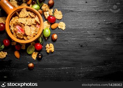 Healthy food. Muesli with forest berries. On a black wooden background.. Healthy food. Muesli with forest berries.