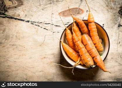 Healthy food. Organic carrots in a bowl . On wooden background.. Healthy food. Organic carrots in a bowl .