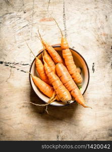 Healthy food. Organic carrots in a bowl . On wooden background.. Healthy food. Organic carrots in a bowl .