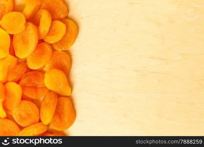 Healthy food organic nutrition. Border frame of dried apricots set fruit on wooden background