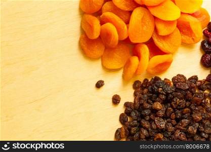 Healthy food organic nutrition. Border frame of dried fruits raisin and apricots on wooden table background