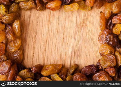 Healthy food organic nutrition. Border frame of raisin on wooden table background