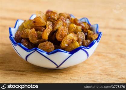 Healthy food organic nutrition. Raisin dried grape in bowl on wooden table background