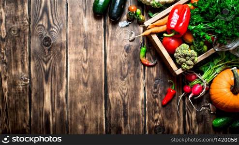 Healthy food. Organic vegetables in an old box. On wooden background.. Healthy food. Organic vegetables in an old box.