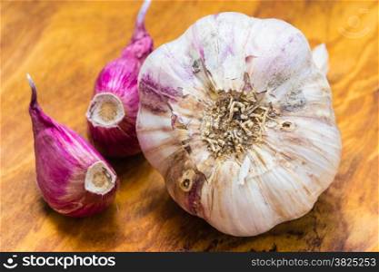 Healthy food. Organic whole garlic and cloves on rustic wooden table background