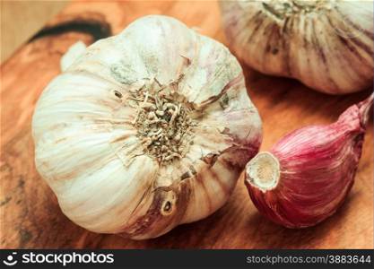 Healthy food. Organic whole garlic and cloves on rustic wooden table background