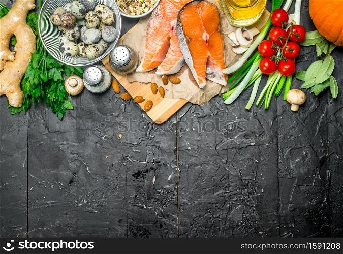 Healthy food. Salmon with vegetables and herbs . On a black rustic background.. Healthy food. Salmon with vegetables and herbs .