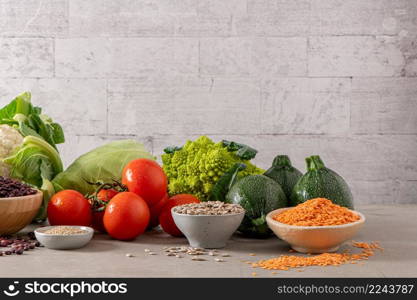 Healthy food selection with vegetables, seeds, superfood, cereals on kitchen countertop.