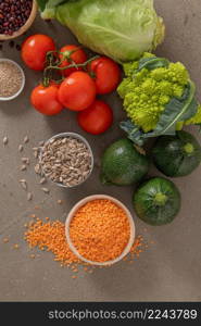 Healthy food selection with vegetables, seeds, superfood, cereals on kitchen countertop.