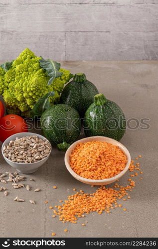 Healthy food selection with vegetables, seeds, superfood, cereals on kitchen countertop.