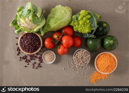 Healthy food selection with vegetables, seeds, superfood, cereals on kitchen countertop.