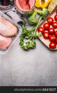 Healthy food with raw chicken breast, fresh seasoning and vegetables on gray stone background