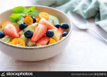 Healthy fresh fruit salad in a bowl on wooden background