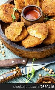 Healthy fried vegetable cutlets with pea in wooden tray. Diet cutlets from peas.