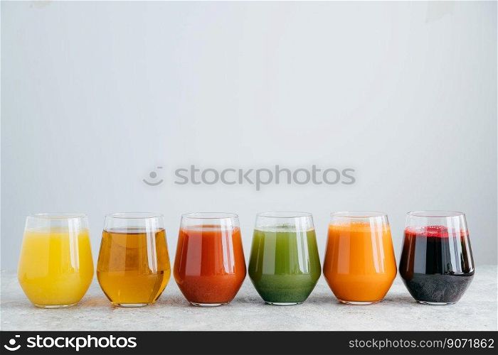 Healthy fruit juice in glasses isolated over white background. Horizontal shot. Delicious and refreshing beverage. Colorful drink