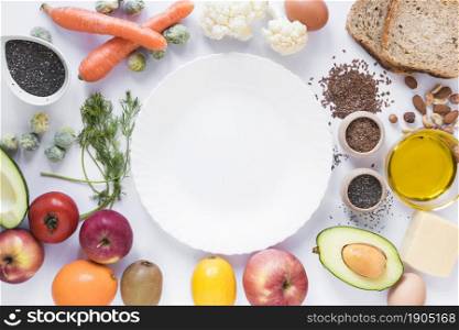 healthy fruits vegetables dryfruits bread seeds cheese egg oil with empty plate white background. Beautiful photo. healthy fruits vegetables dryfruits bread seeds cheese egg oil with empty plate white background