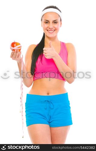 Healthy girl holding apple with measuring tape and showing thumbs up