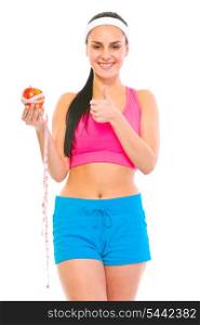 Healthy girl holding apple with measuring tape and showing thumbs up