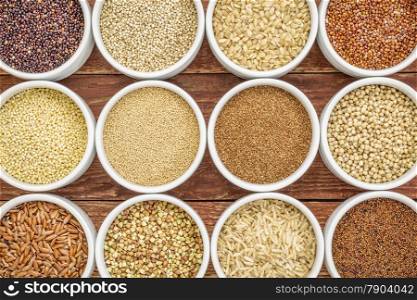 healthy, gluten free grains abstract (quinoa, brown rice, millet, amaranth, teff, buckwheat, sorghum), top view of small round bowls against rustic wood
