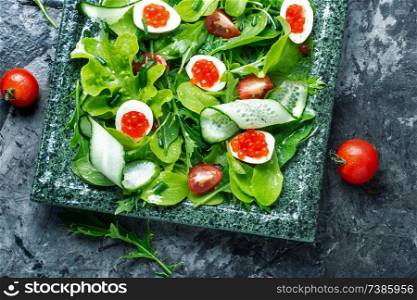 Healthy green salad.Spring salad with greens, cucumber, egg and red caviar.. Fresh green salad