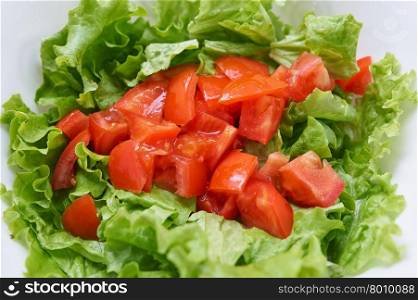 Healthy green salad, tomatoes in white bowl