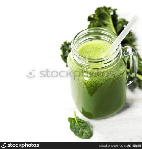 Healthy green smoothie with straw in a jar mug on white background