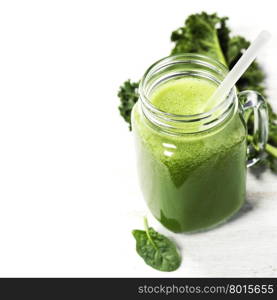 Healthy green smoothie with straw in a jar mug on white background