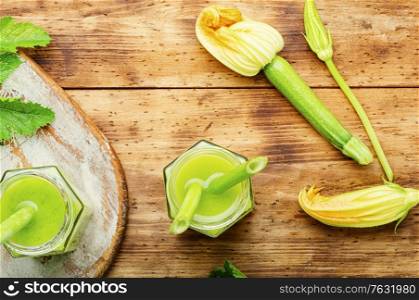 Healthy green smoothie with zucchini in glass jars on a rustic wooden background. Healthy green smoothie with zucchini