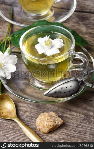 healthy green tea with Jasmine. glass of herbal tea with the aroma of Jasmine flower on wooden background