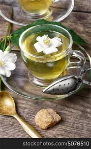 healthy green tea with Jasmine. glass of herbal tea with the aroma of Jasmine flower on wooden background