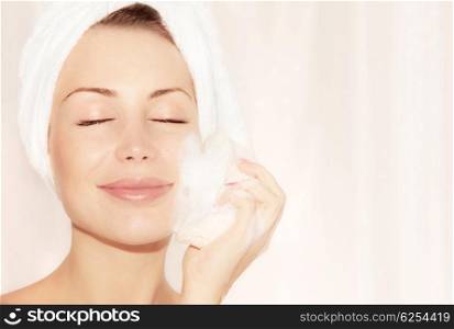 Healthy happy girl taking bath, beautiful young female cleaning face skin, portrait over soft light background, hygiene and day spa