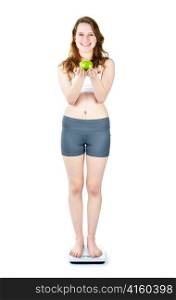 Healthy happy young woman holding apple on bathroom scale isolated on white