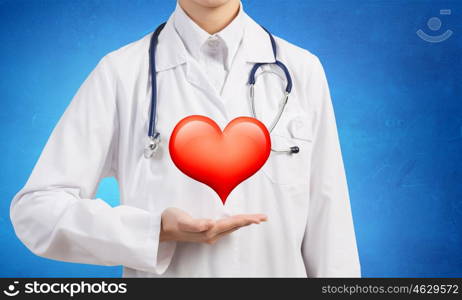 Healthy heart. Close up of female doctor holding heart in hands