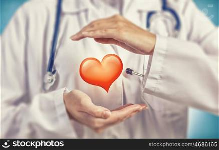Healthy heart. Close up of female doctor holding heart in hands