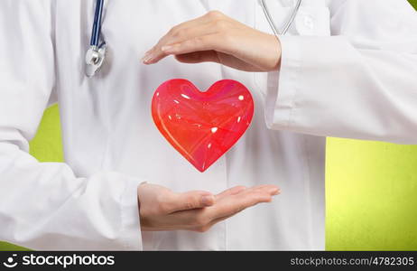 Healthy heart. Close up of female doctor holding heart in hands