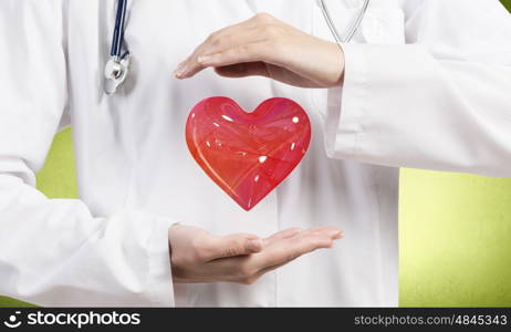 Healthy heart. Close up of female doctor holding heart in hands