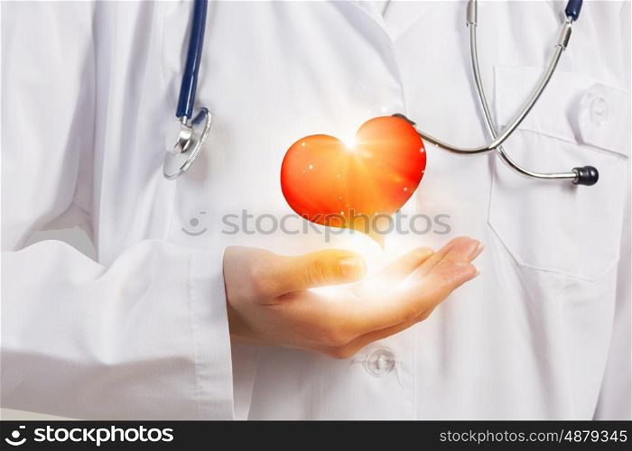 Healthy heart. Close up of female doctor holding heart in hands