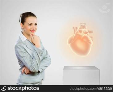 Healthy heart. Image of businesswoman looking at icon. Health care