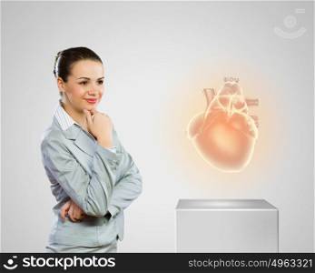 Healthy heart. Image of businesswoman looking at icon. Health care
