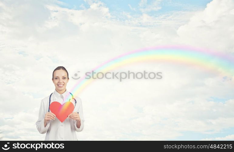 Healthy heart. Young female doctor holding red heart in hands