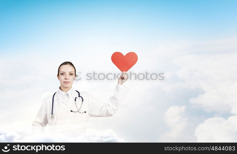 Healthy heart. Young female doctor holding red heart in hands