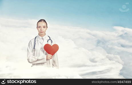 Healthy heart. Young female doctor holding red heart in hands