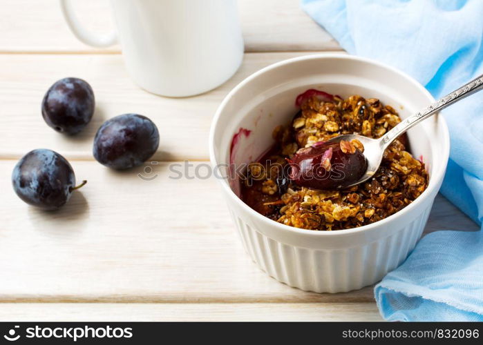 Healthy homemade plum granola in the white baking ceramic form