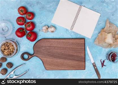 healthy ingredient kitchen utensil with open blank diary blue textured backdrop