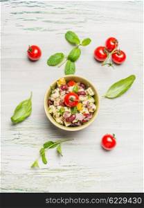 Healthy kidney beans salad with Goat cheese and tomatoes on light rustic background, top view