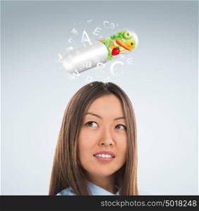 Healthy life concept. Woman with vitamins overhead